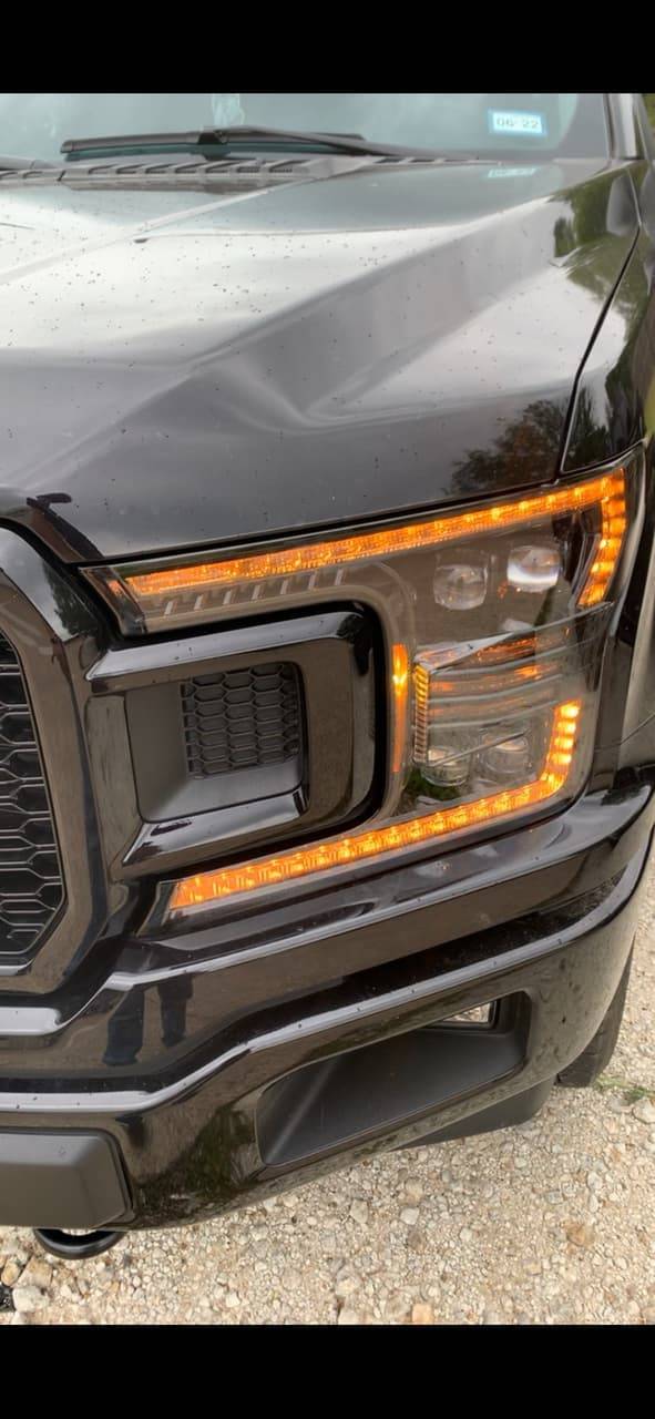 Custom headlight upgrade with amber running lights on a black F-150